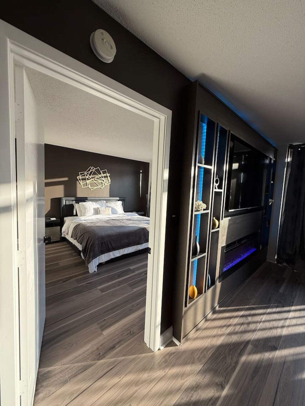 A modern bedroom with a bed, bedside tables, and a built-in TV.
