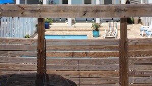 Un immeuble de deux étages doté de balcons, d’une piscine et d’un espace extérieur aménagé pour s’asseoir.