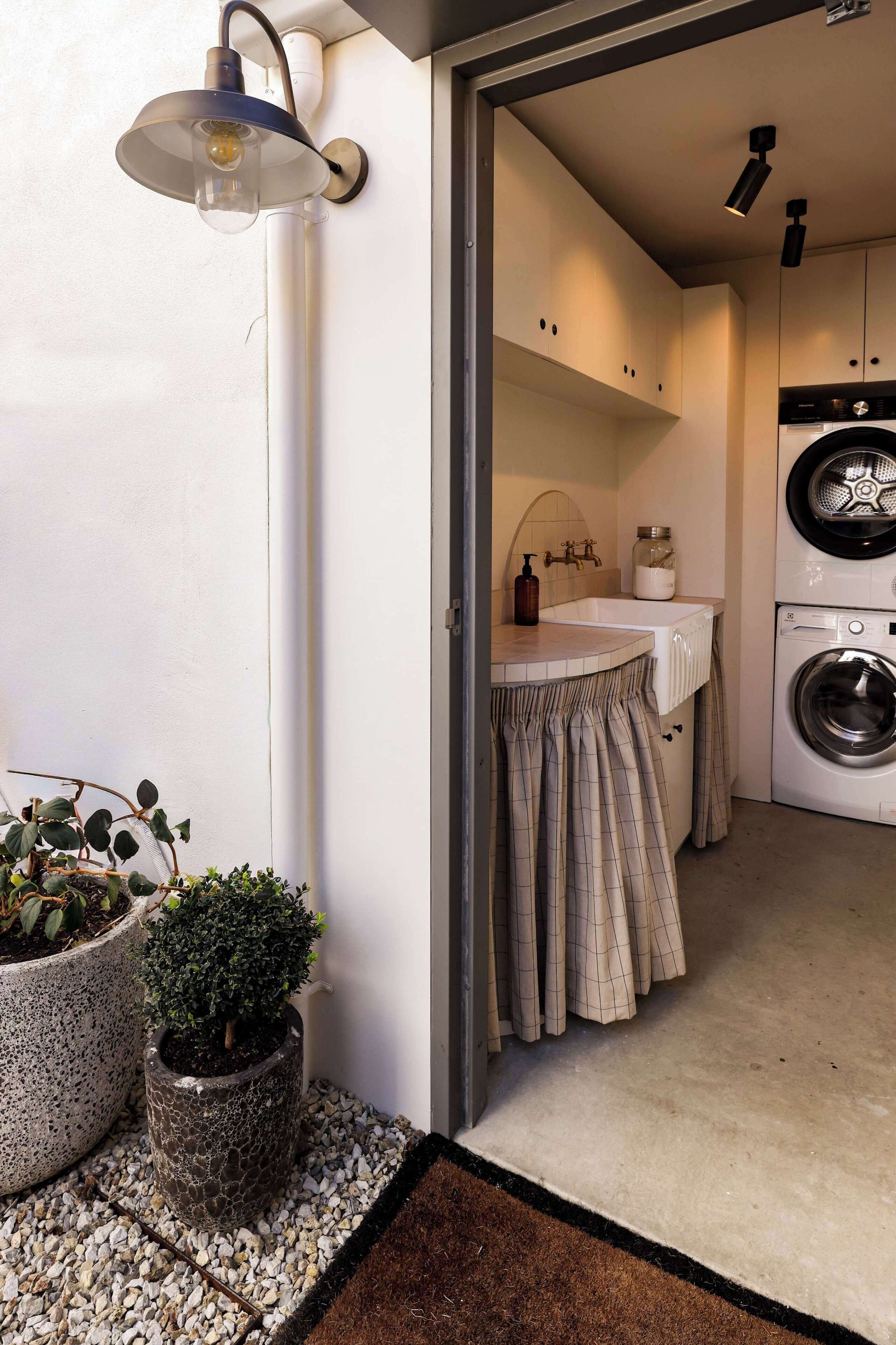 A laundry area with a washing machine, a sink, and a towel rack.
