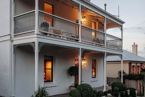 Ein zweistöckiges Gebäude mit Balkonen, großen Fenstern und einer Veranda.