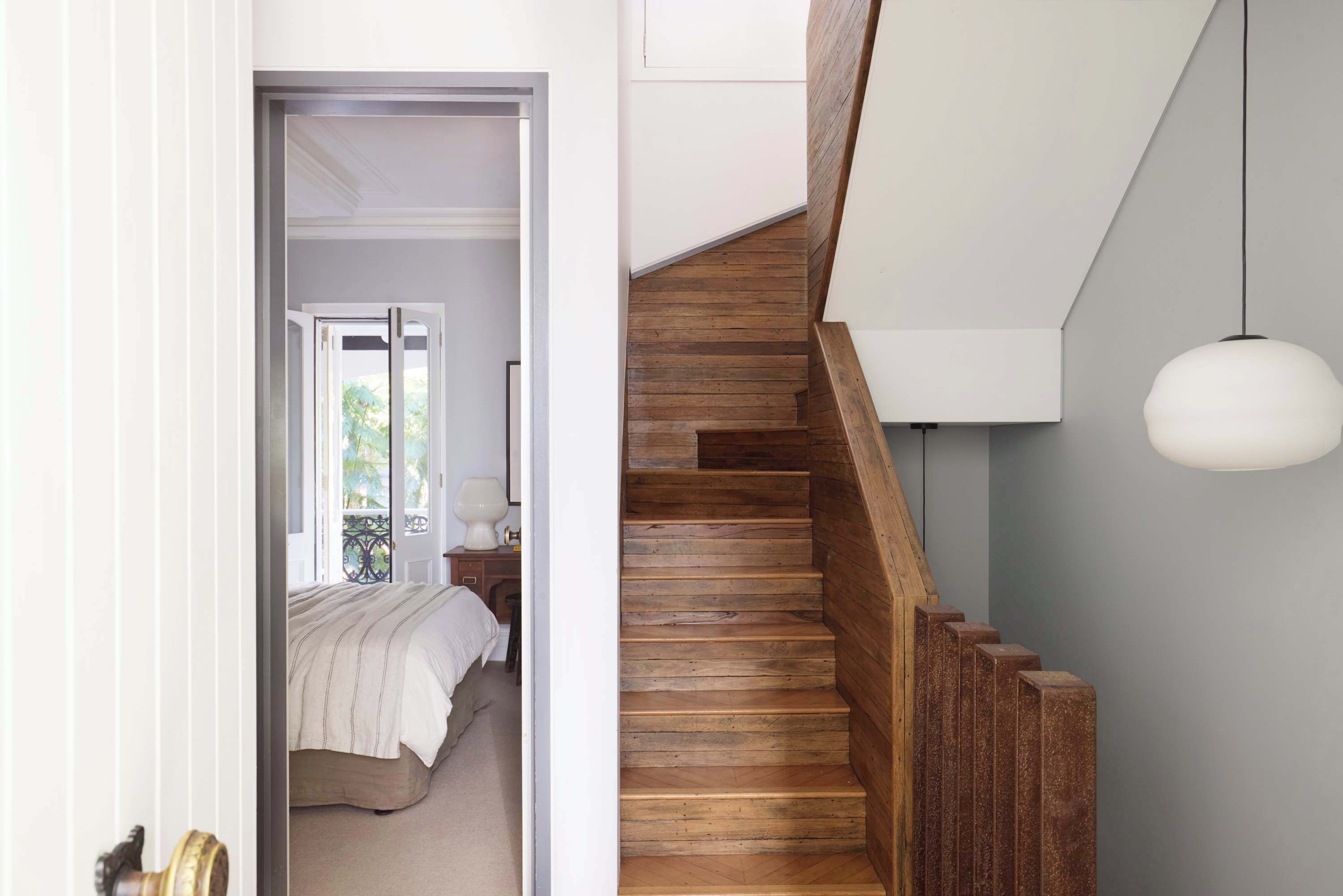 A bedroom with a bed, a nightstand, and a window.