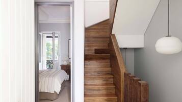 A bedroom with a bed, a nightstand, and a window.