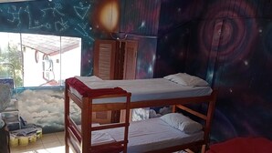 A bunk bed room with a galaxy-themed wall mural, a window with a view of a building, and a ladder against the wall. - espiral lar (Florianopolis)