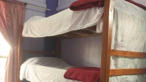 A bunk bed with three levels, each with a white mattress and a red blanket. - espiral lar (Florianopolis)