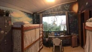 A dormitory room with bunk beds, a desk, and a window. - espiral lar (Florianopolis)