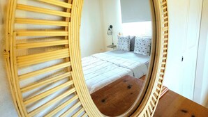 Een ronde spiegel met houten lijst op een houten tafel.