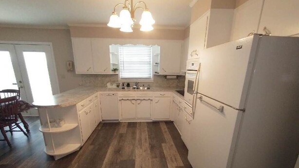 A compact kitchen with white cabinets, a built-in oven, and a refrigerator. - Renovated rural 3-bedroom 2-bathroom ranch style home in Smithville, TN (Smithville)