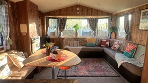 Un intérieur de camping-car confortable, avec un coin repas, des sièges et une vue sur l’extérieur.