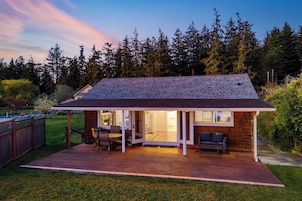 A single-story house with a covered patio, a small deck, and a fenced backyard.