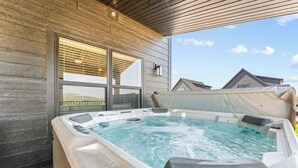 A hot tub with a wooden exterior wall and large windows.