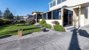 A modern building with large windows, a paved driveway, and a well-maintained lawn. - Waterfront | Great Views | Affordable | Unit 3 - KK61643 (Kaikoura)