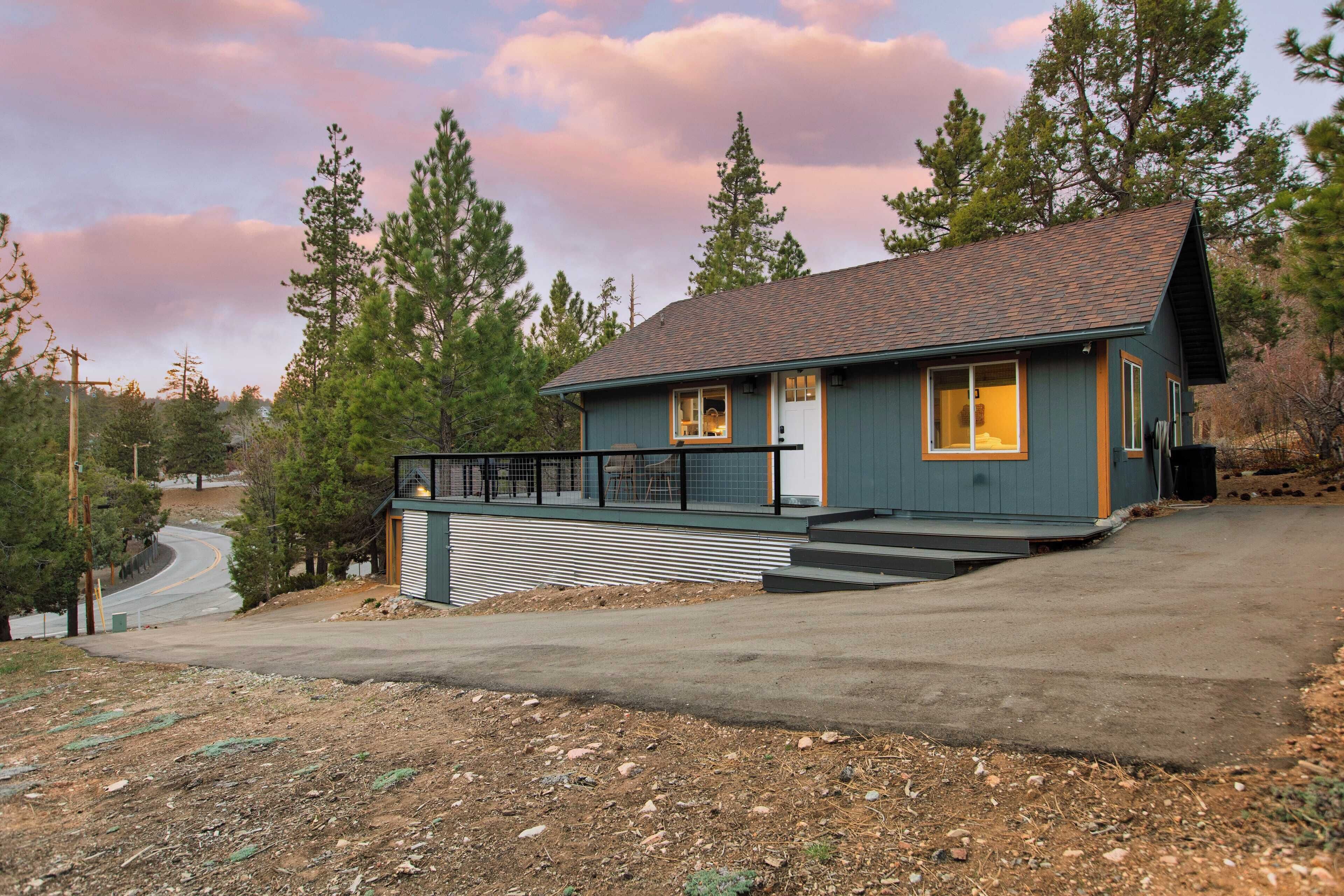 A two-story house with a sloped roof, a front porch, and a garage.