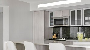 A modern kitchen with a microwave, stove, and bar area. - Marriott's Crystal Shores, Marco Island - 3 Bedroom (Marco Island)