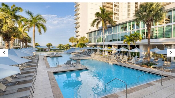 A hotel pool area with multiple pools, sun loungers, and umbrellas. - Marriott's Crystal Shores, Marco Island - 3 Bedroom (Marco Island)