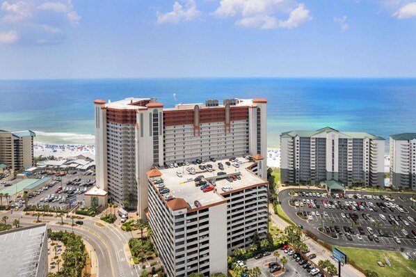 Um hotel moderno com vários níveis de estacionamento e vista para a praia.