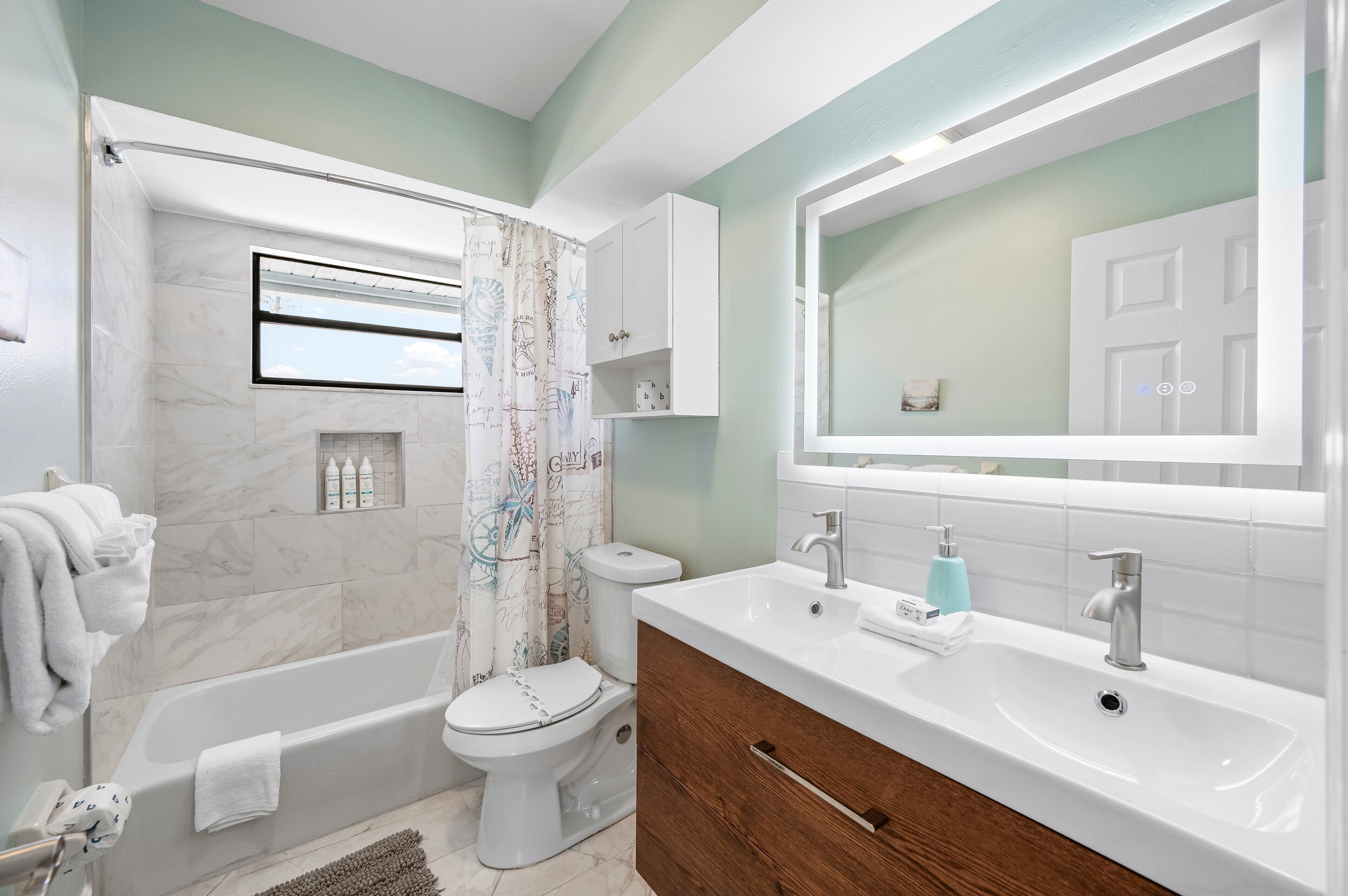 Ein modernes Badezimmer mit Badewanne, Toilette und Waschtisch.