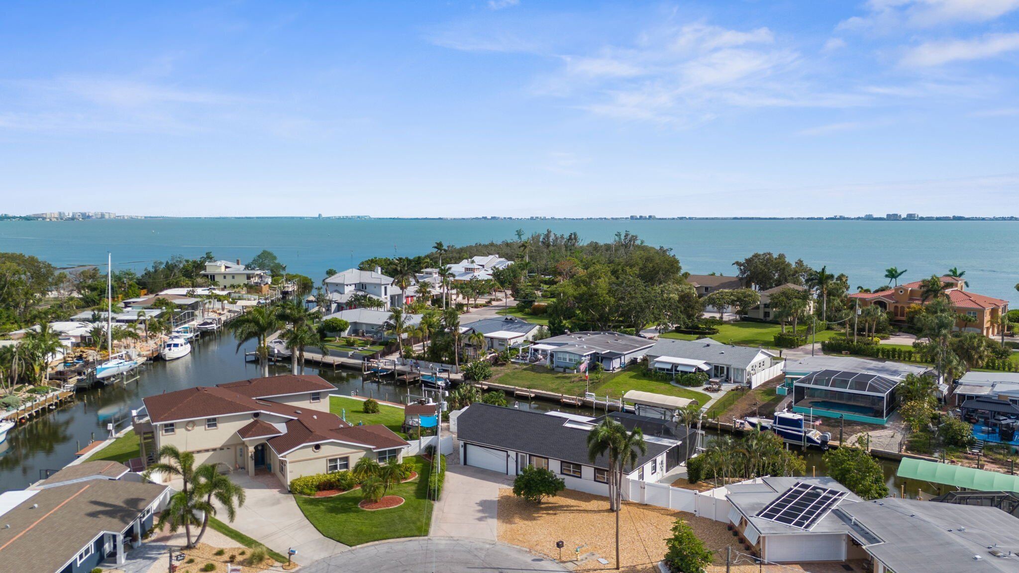 A coastal residential area with houses, a marina, and a view of the ocean.