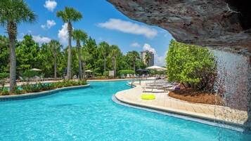 Una piscina con sillas de descanso y palmeras.