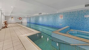 A swimming pool with a tiled wall, a shallow water sign, and a lifebuoy. - Cozy Studio with Gym and Pool Near Chatswood Station (Liberty Grove)