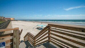 A beach with wooden boardwalks, a sandy beach, and a clear blue sky.