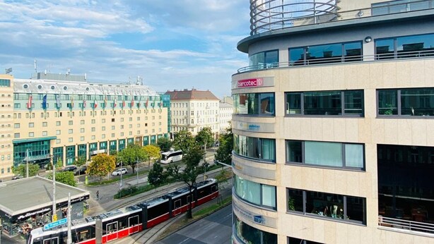 A modern building with a 'CENTER' sign, a barcotec logo, and a tram line in the foreground.