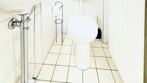 A small, white bathroom with a toilet, sink, and a window with a plant. - Comfy Room in a Shared Apt, Near FAC Platz (Vienna)