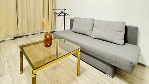 A living room with a sofa, a glass coffee table, and a lamp. - Comfy Room in a Shared Apt, Near FAC Platz (Vienna)