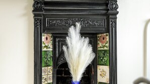 Une cheminée ornée d’un vase bleu et de carreaux décoratifs.