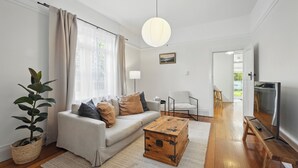 Een moderne woonkamer met een bank, salontafel en televisie.