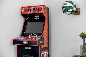 An arcade machine with a basketball theme, including a basketball hoop and the NBA logo.