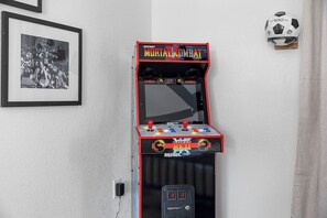 A Midway arcade machine for Mortal Kombat Arcade, with a mounted soccer ball and a framed photograph on the wall.