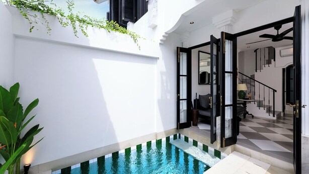 Un área de piscina interior moderna con una puerta de vidrio que da a una escalera.