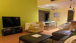 A living room with a TV, sofa, and coffee table. - Aloha home-Amazing location for all GC has to offer amazing home for the family. (Labrador)