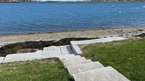 A stone staircase leading to a grassy area by a body of water. - Enjoy Stunning Ocean Views & Coastal Access at Sea Mist Overlook! (Harpswell)