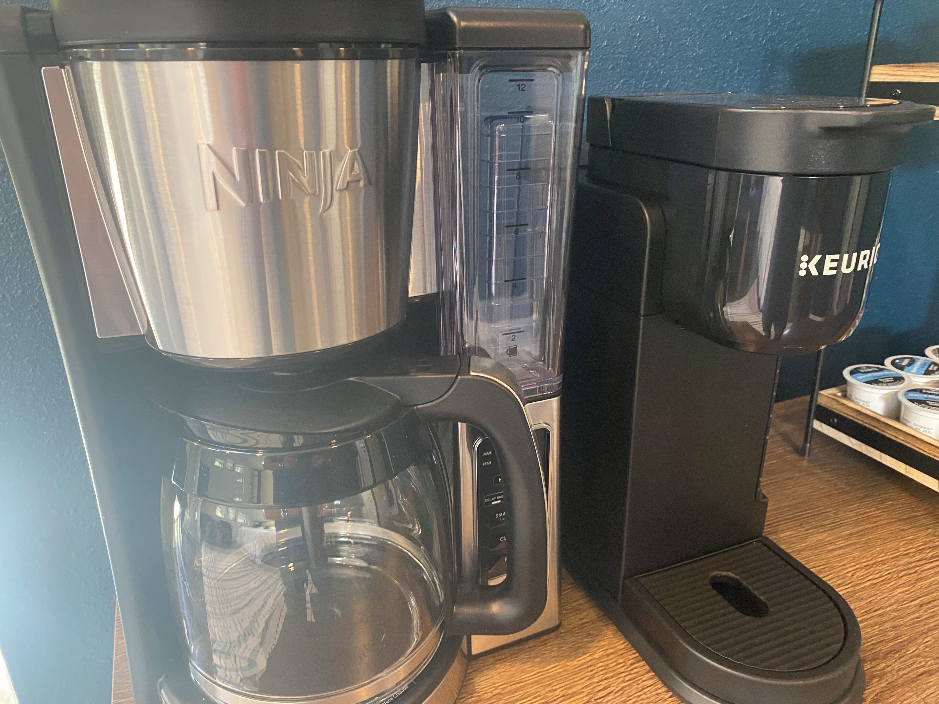 Eine Kaffeemaschine mit Edelstahlkanne und schwarzem Fuß.