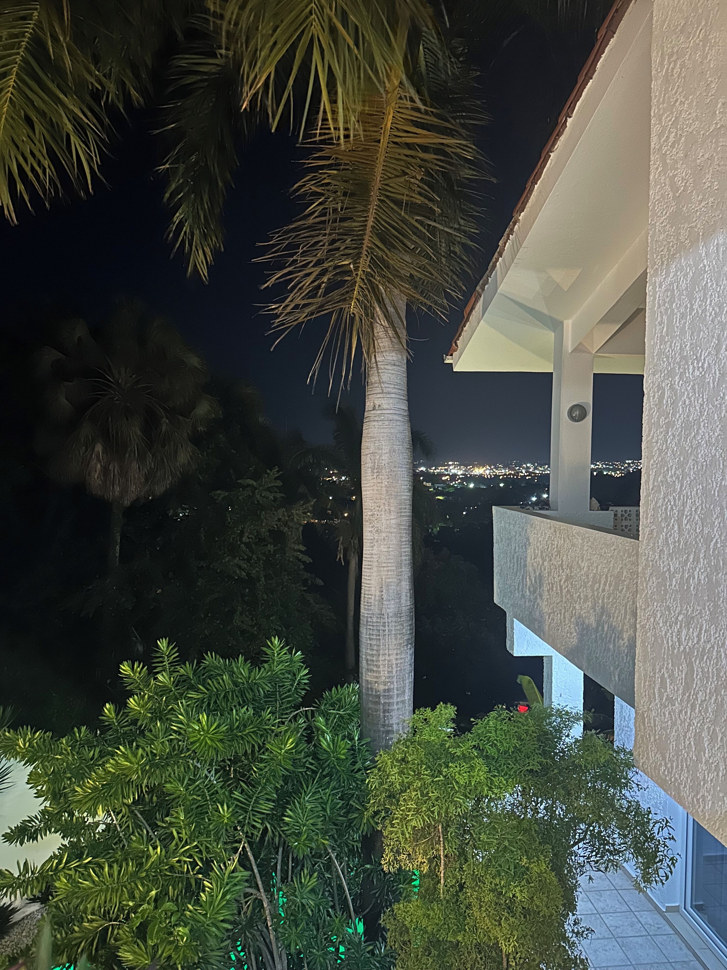 Ein Nachtblick auf ein Gebäude mit einem Balkon, der auf einen Stadtblick blickt.