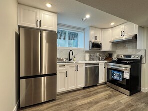Microwave, oven, stovetop, dishwasher - Modern & Stylish 2-Bedroom Basement Suite (Calgary)