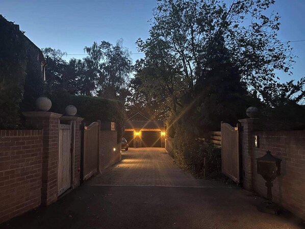 Un camino de entrada con portón que conduce a un edificio con garaje.