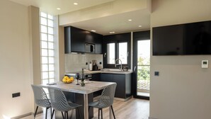 A modern kitchen with a dining area, large windows, and a flat-screen TV. - Kourouta Luxury Suites with Pool nr4, Kourouta, Greece (Kourouta)