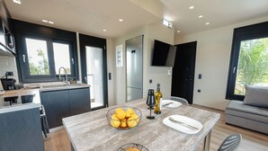 A modern kitchen with a central island, a dining area with a table and chairs, and a sofa in the living area. - Kourouta Luxury Suites with Pool nr4, Kourouta, Greece (Kourouta)