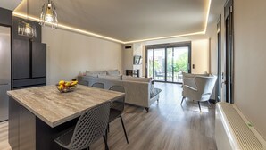 Eine moderne Küche mit Essbereich, einer Couch und einem großen Fenster.