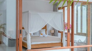 A modern bedroom with a canopy bed, glass doors, and a view of the outdoors. - "LARRI" - Architect & Luxurious 3BR - Canggu Beach (Bali)