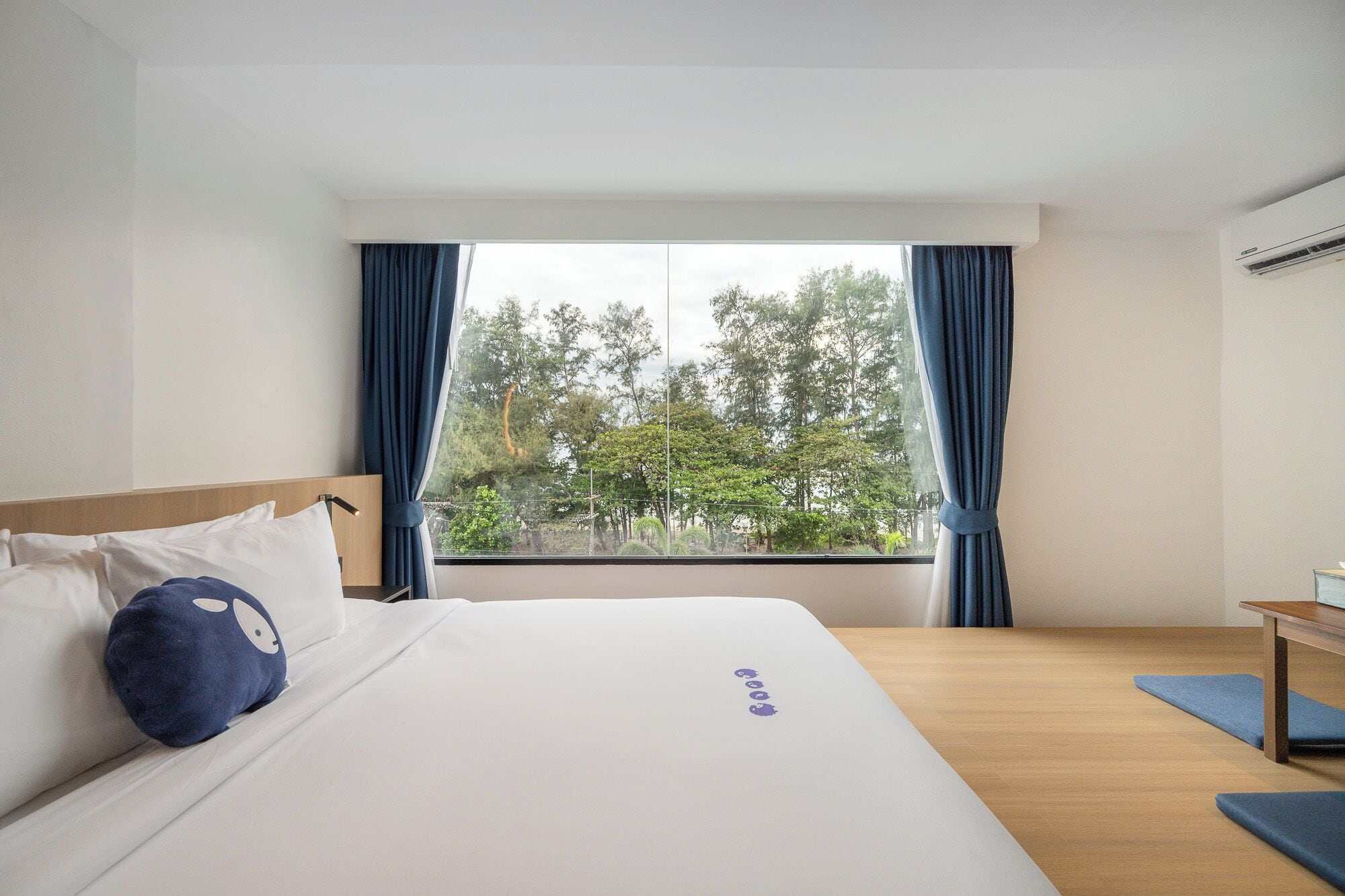 Una habitación de hotel con cama, escritorio y ventana con cortinas.
