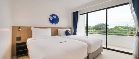 A hotel room with two beds, a wooden headboard, a large window with a view of greenery, and a blue decorative wall piece.