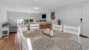 Un salon moderne avec une table à manger, des chaises blanches et un canapé.