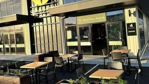 Ein modernes Gebäude mit einem Restaurant namens 'mocha n more' im Erdgeschoss.