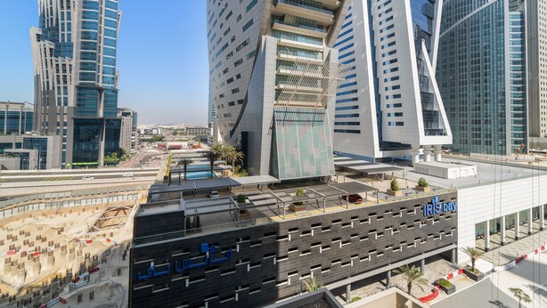 A modern building with a parking garage labeled "IRISDAY" and a distinctive architectural design. - Merano - 805 1BD in Dubai (Dubai)