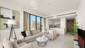 A modern living room with a sofa, coffee table, and a television. - Canal Front Building 9 A - 1001 2BD (Dubai)