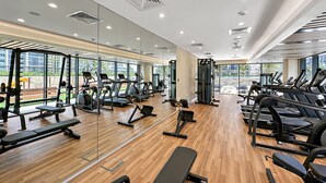 Ein modernes Fitnessstudio mit Laufbändern, Kraftgeräten und Bänken.
