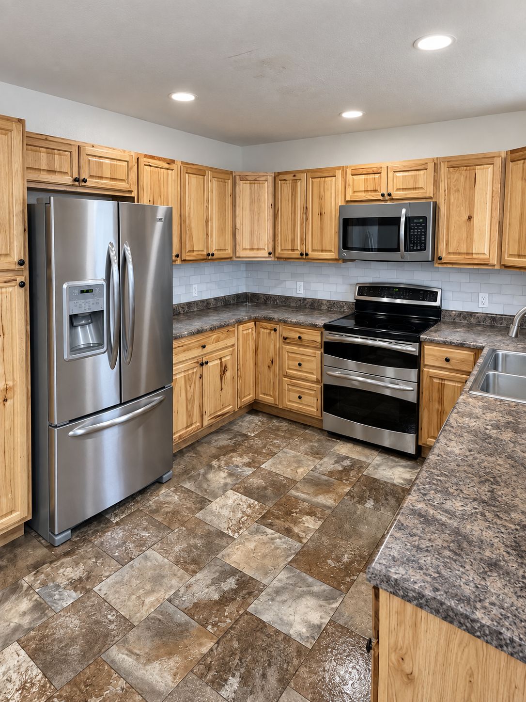 A kitchen with wooden cabinets, stainless steel appliances, and a granite countertop.
